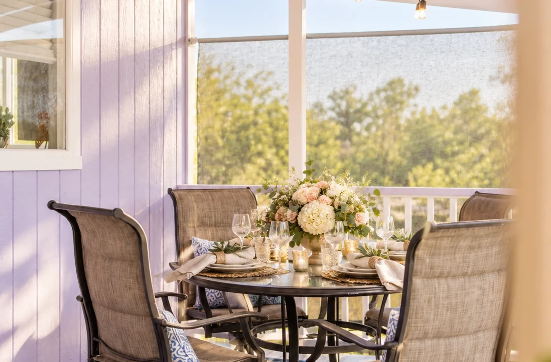 Covered cottage porch arranged for an intimate event dining setup