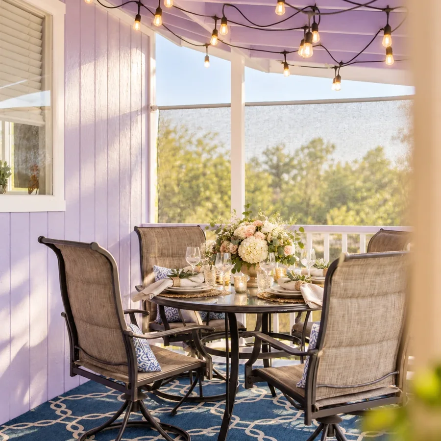 Covered cottage porch arranged for an intimate event dining setup